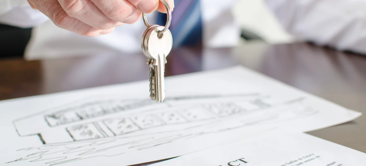 real estate lawyer handing the keys of a house to a happy client